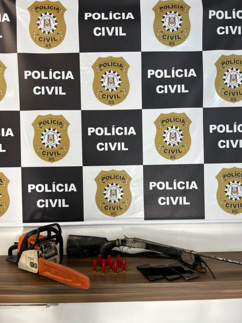 Itens expostos em cima de mesa com banner da Polícia Civil ao fundo