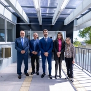 Homens e mulheres posados para fotos embaixo de cobertura mostrando parte de obras